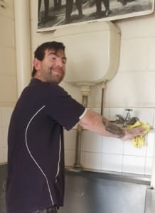 Student cleaning bathroom