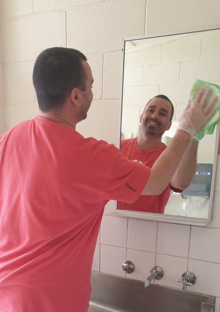 Student cleaning mirror