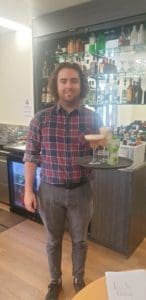 Student pictured with tray of cocktails