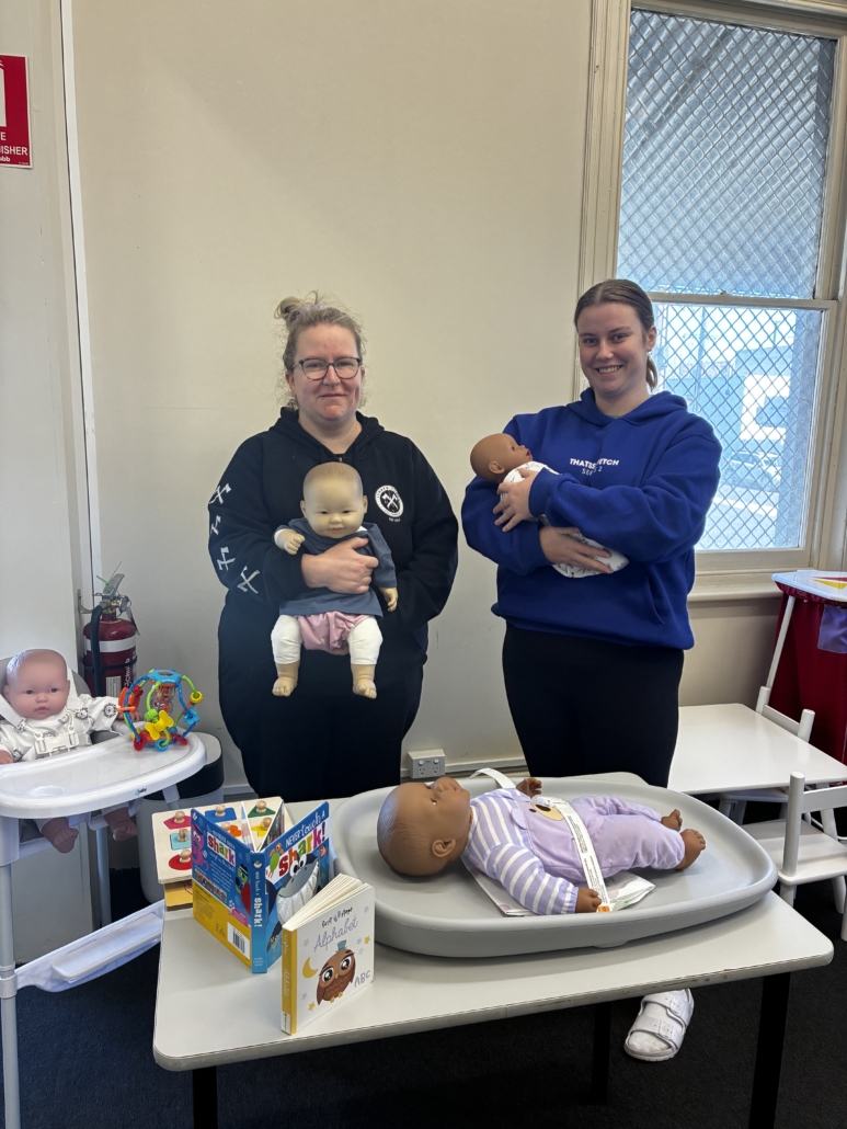Students holding baby dolls